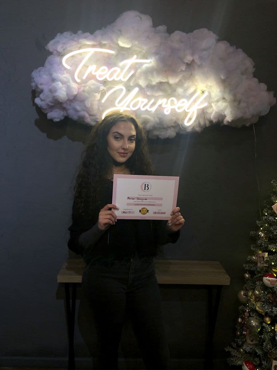 A graduate with her certificate in the training studio