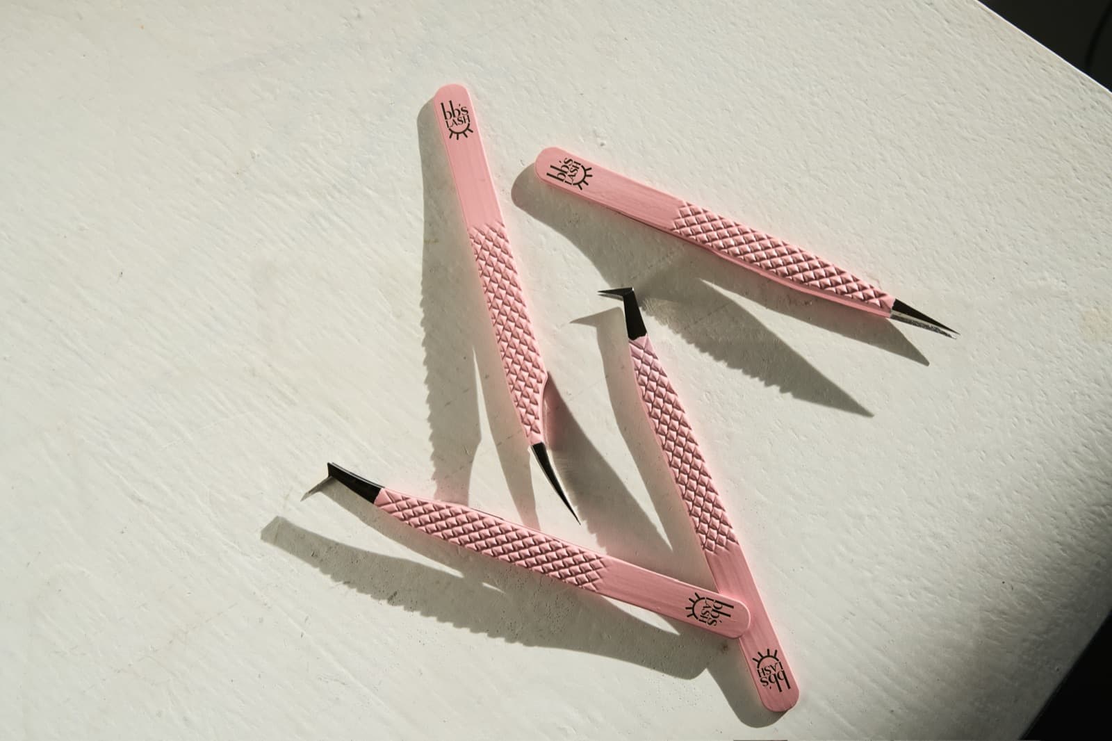 BB's Lash branded tweezers photographed on white